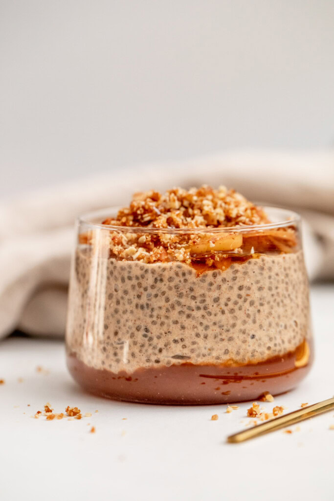Cup filled with apple butter, chia pudding, sauteed apples and a date oat crumble.