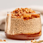 Close up of a cup layered with apple butter, chia pudding, sauteed apples and crumble topping.