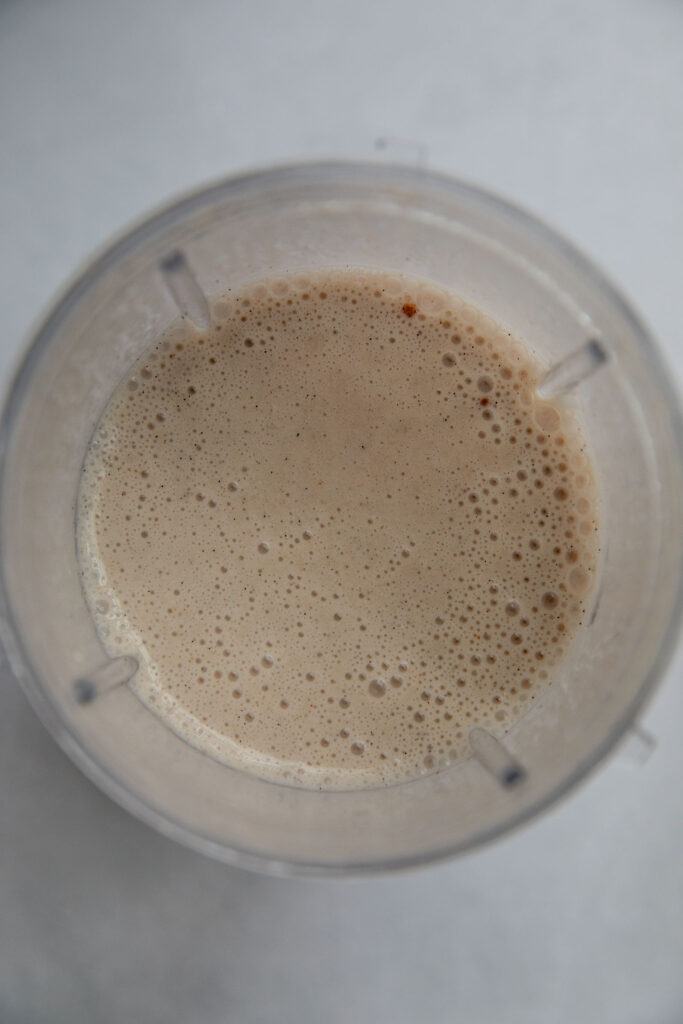 Blended banana milk in a blender cup.