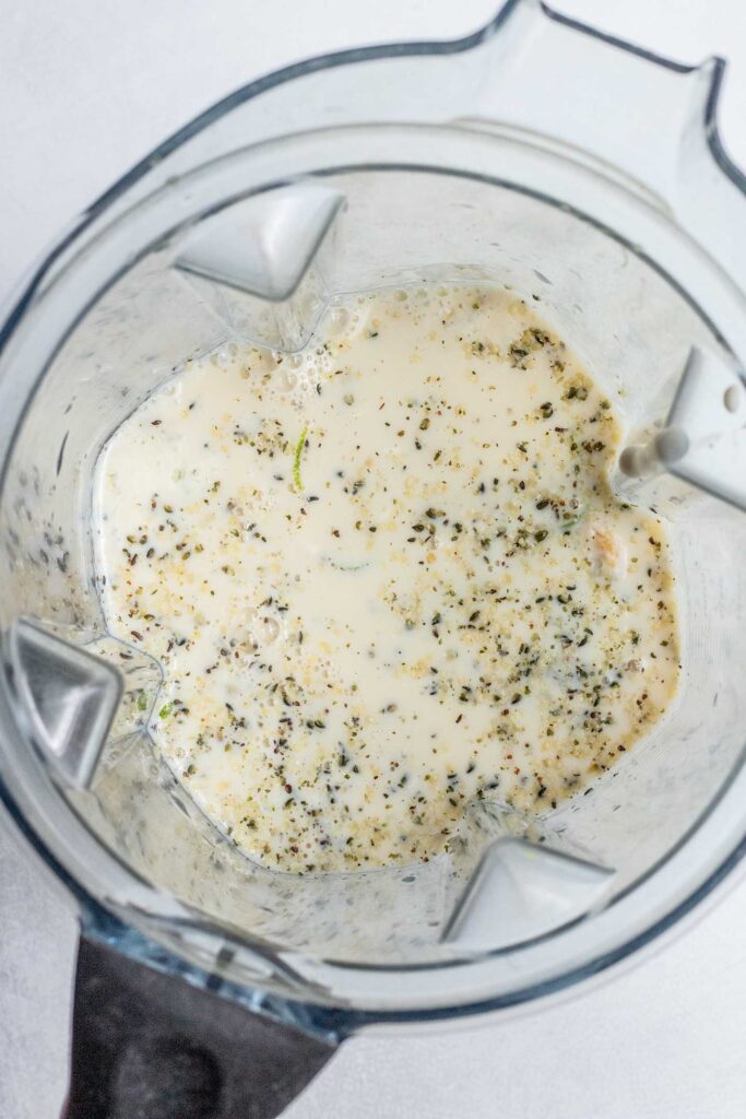 Frozen mango, hemp hearts, lime zest and milk in a blender cup.