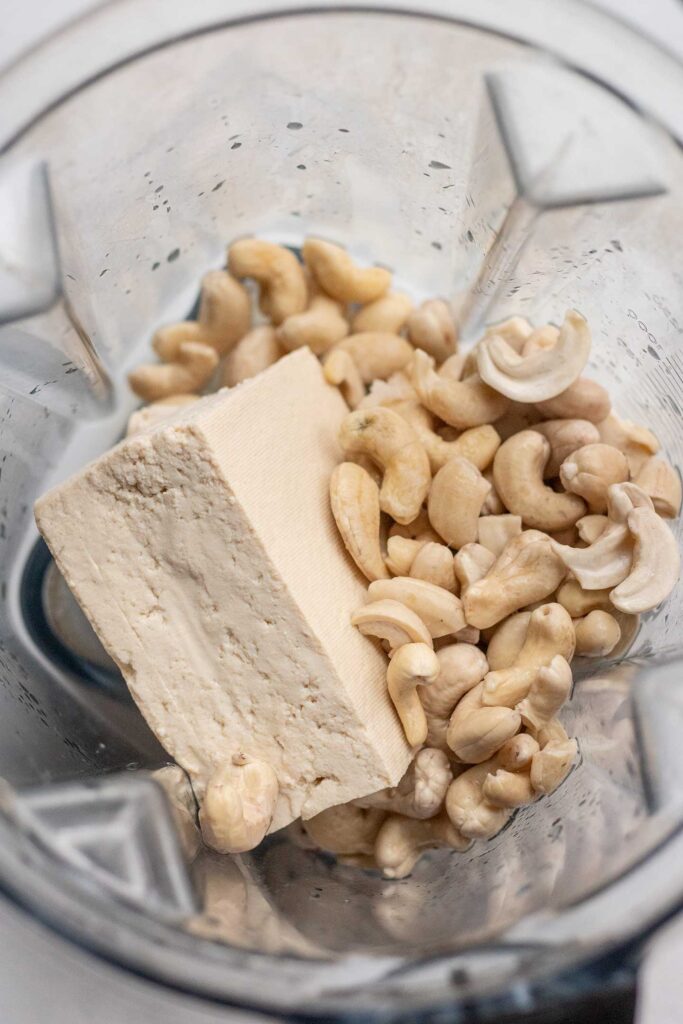 Tofu, soaked cashews, miso paste, salt, lemon juice and apple cider vinegar in a blender cup.