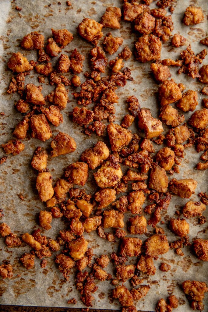Fully baked crispy tofu on a baking tray.