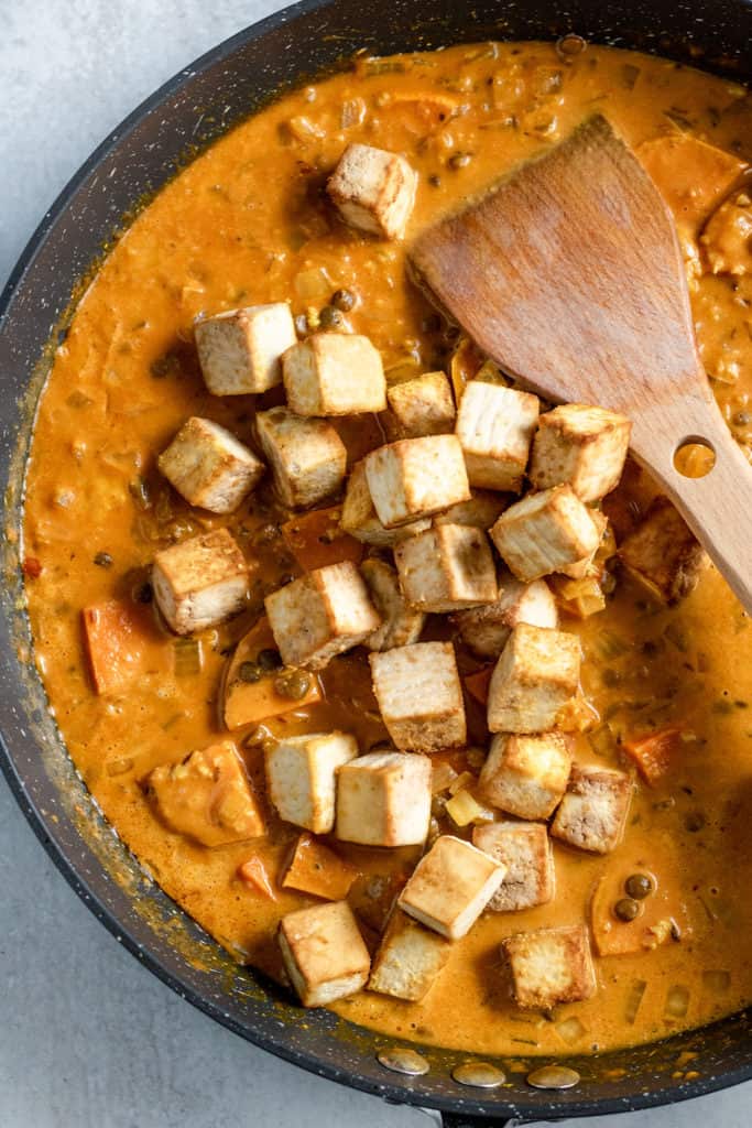 Stirring in tofu to the final sauce.