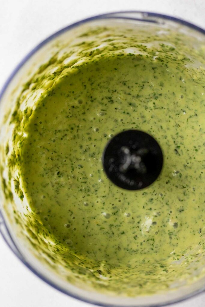 Blended lemon basil sauce in a blender cup.