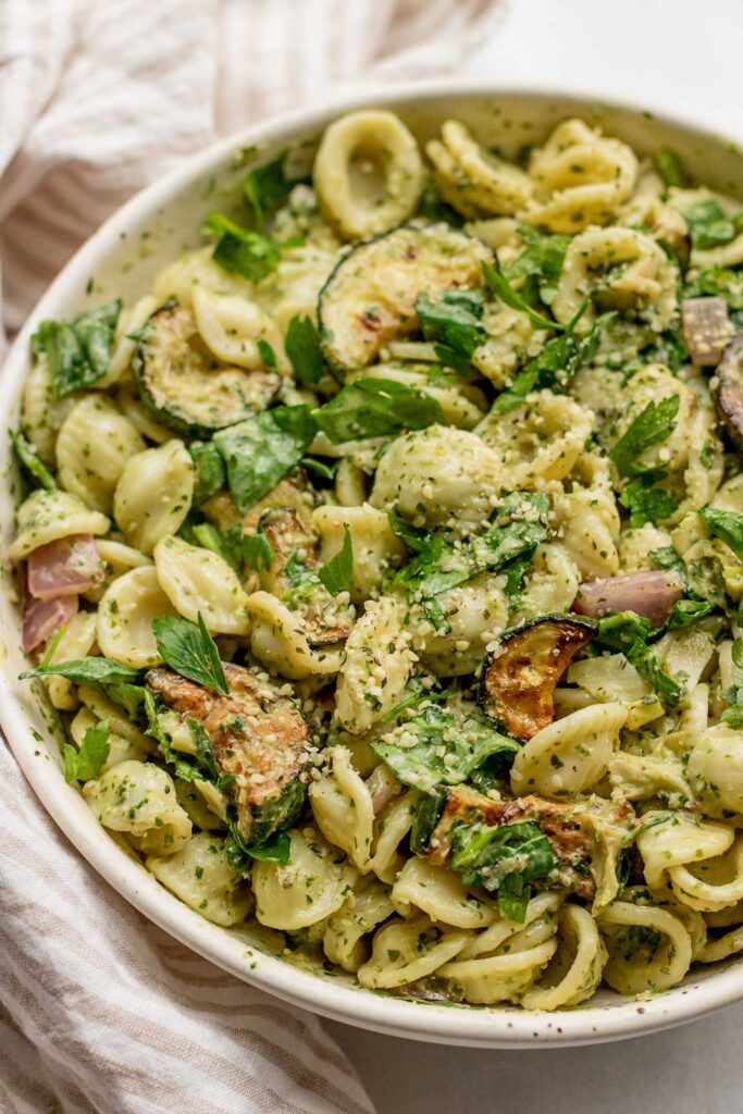 Large mixing bowl filled with lemon basil pasta salad topped with hemp hearts.
