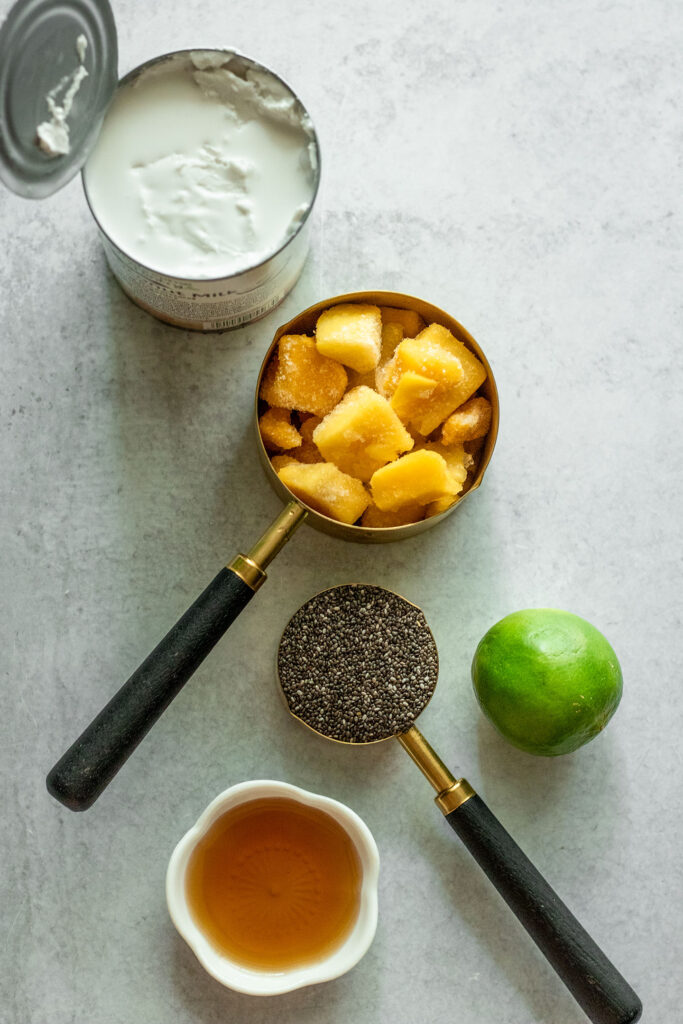 Mango chia pudding ingredients including frozen mango, lime, chia seeds, maple syrup and coconut milk.
