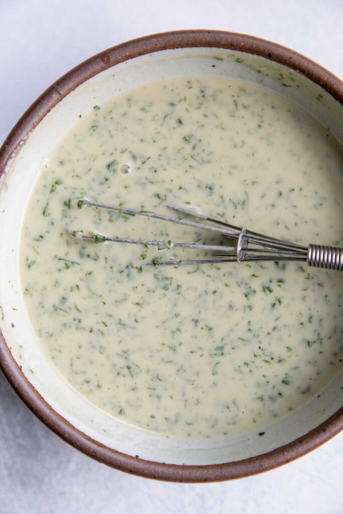 Herby cilantro lime dressing whisked in a small bowl.