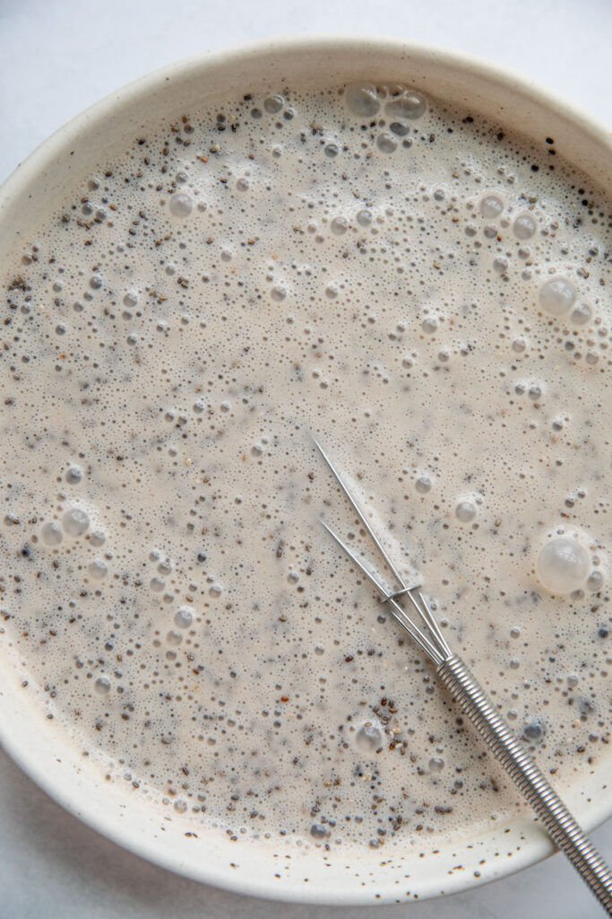 Mixing the banana milk together with the chia seeds in a bowl.
