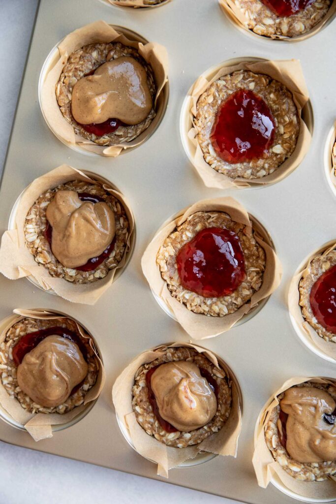 Layering the jelly and peanut butter on top of the oat base.