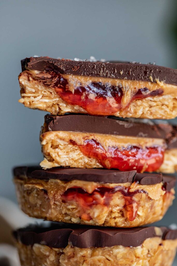 Close up of a stack of peanut butter jelly cups showing the inside of one of the cups cut in half.