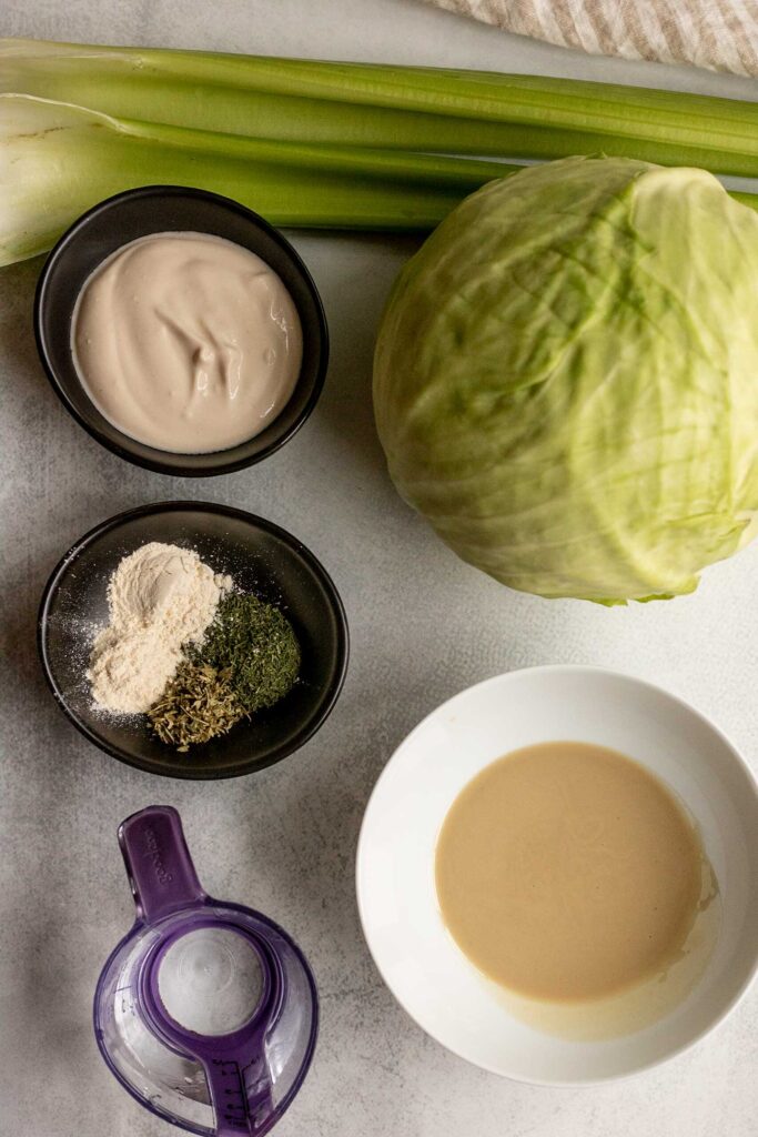 Cabbage, yogurt, herbs, water, tahini and water on a working surface.