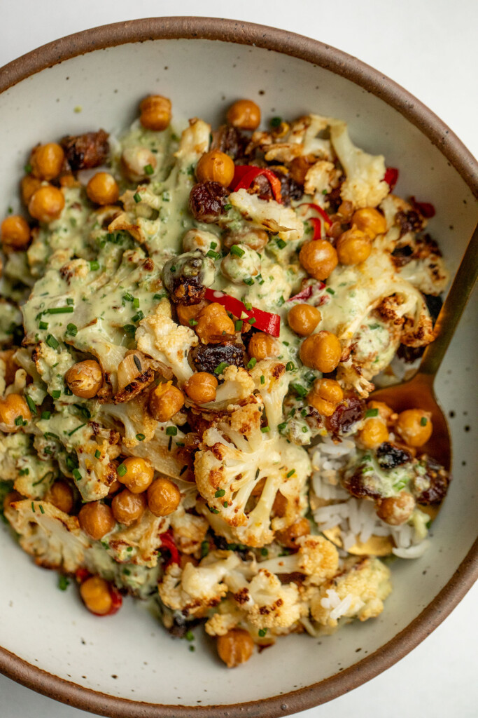 Grabbing a spoon of rice and the cauliflower date salad from the serving bowl.