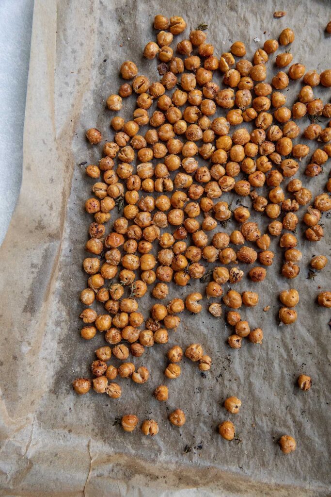 Seasoned roasted chickpeas on a baking tray.