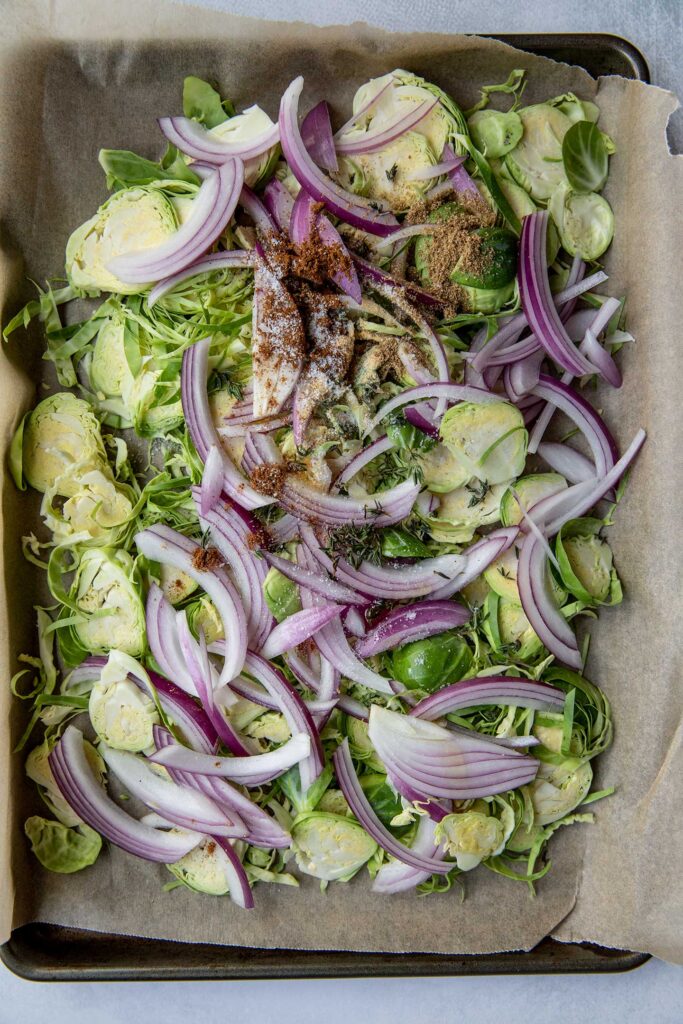 Seasoned brussels sprouts on a baking tray.