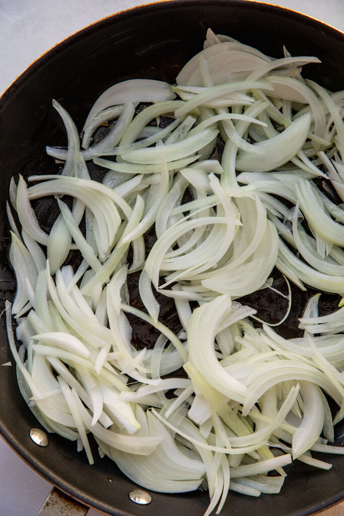Initial cooking of onions in a sauté pan.