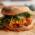 English muffin stuffed with mashed avocado, tempeh hash, and spinach.