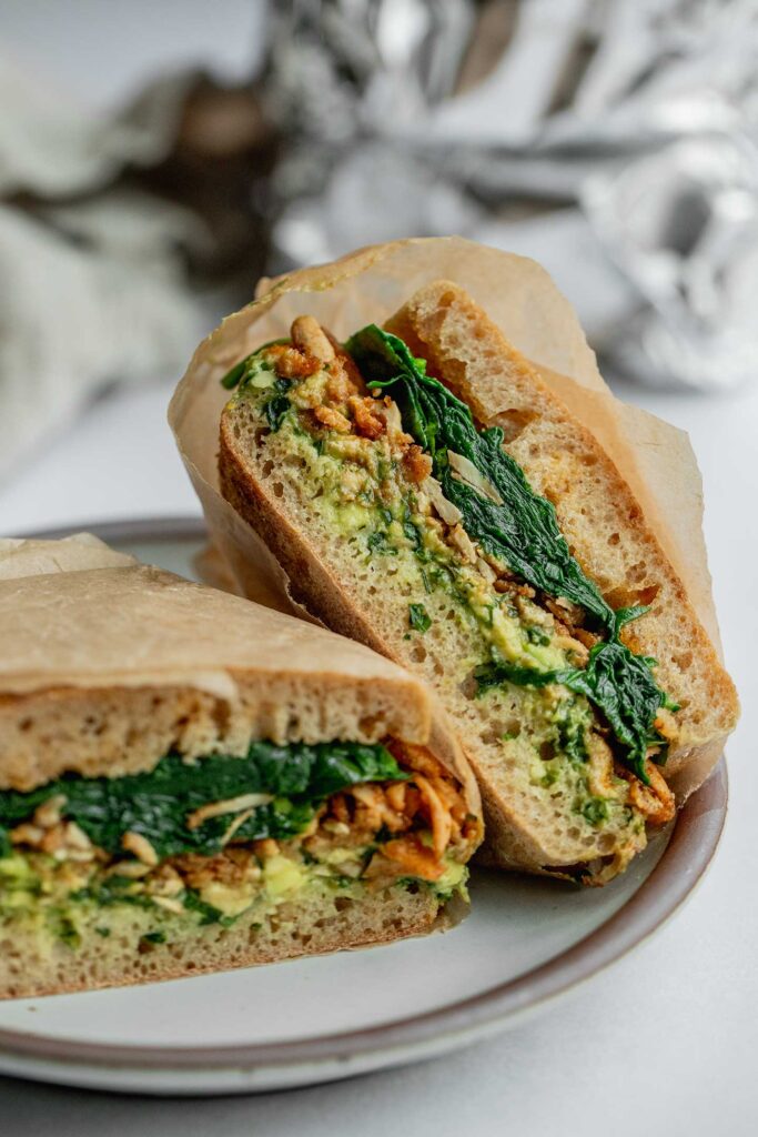 Shredded tofu breakfast sandwich on a plate cut in half. 