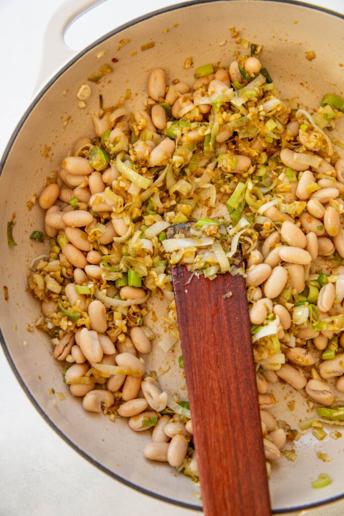 Stirring in the beans and nutritional yeast with the leeks.