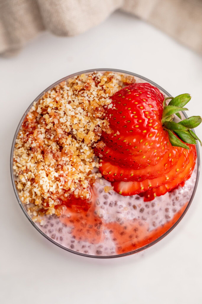 Top down view of a cup of chia pudding topped with an almond date crumble.