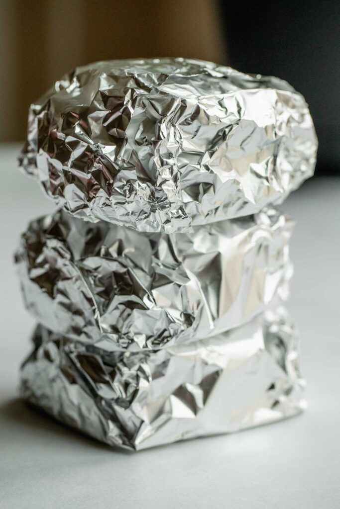 Breakfast sandwiches tightly wrapped in tin foil.